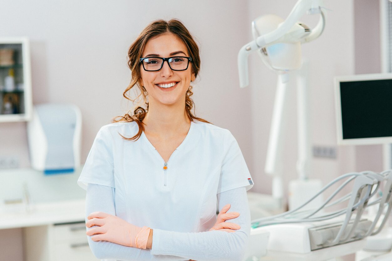 Google Ads Management For Dentists, proud cosmetic dentist smiling in her dental clinic